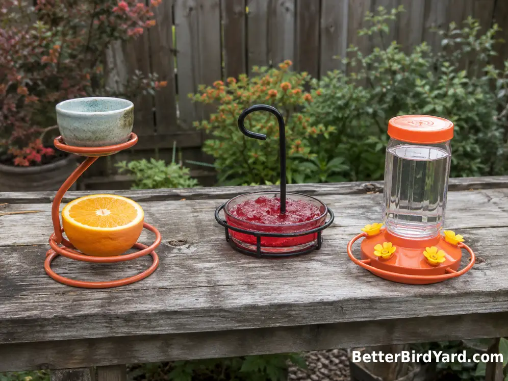 Orange, jelly, and nectar-style oriole feeders sit on a backyard potting bench.